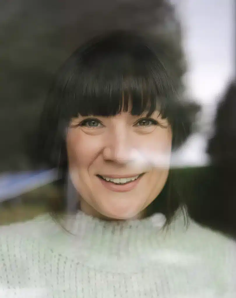 Businessportrait einer Frau hinter einer Scheibe